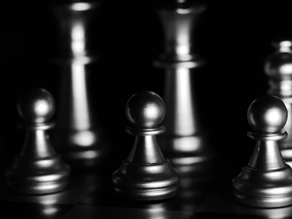 一个戏剧性的灰色比例的国际象棋人物在黑暗中闪烁着光芒 — 图库照片