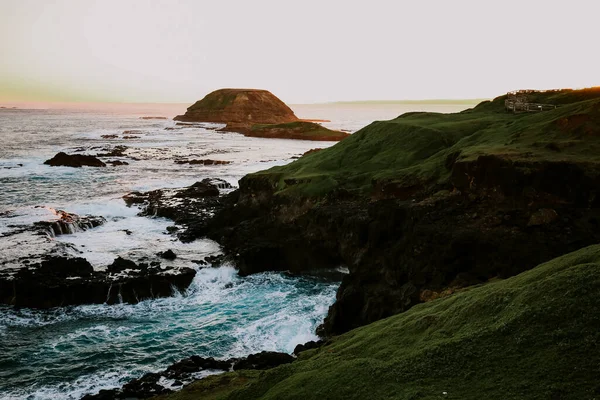 Ένα Κοντινό Πλάνο Κυματιστή Θάλασσα Στα Βράχια Καλυμμένη Πράσινο Ηλιοβασίλεμα — Φωτογραφία Αρχείου