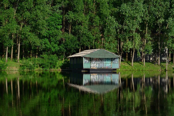 Ein Holzhaus Einem Fluss Dessen Spiegelung Von Bäumen Umgeben Ist — Stockfoto