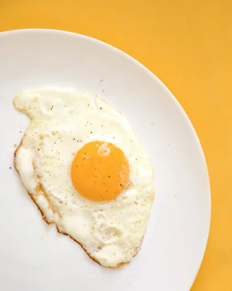 Vemos Ovo Frito Uma Placa Branca Com Fundo Amarelo — Fotografia de Stock