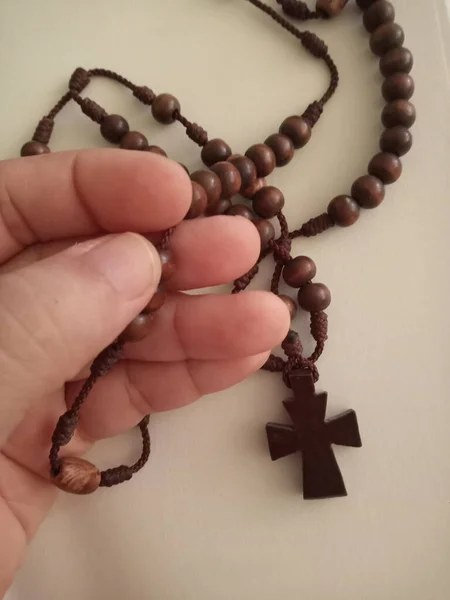 手に聖なる木製のキリスト教徒の十字架のクローズアップショット — ストック写真