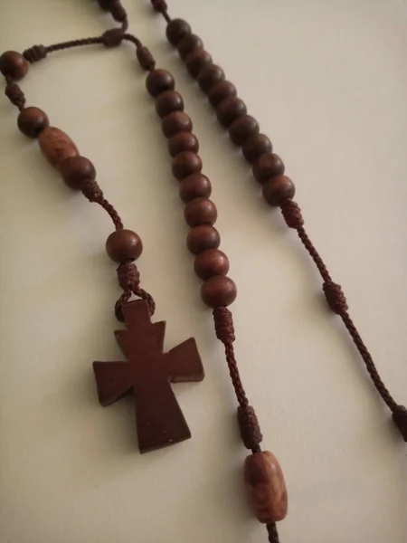 Zbliżenie Ujęcie Świętego Drewnianego Chrześcijańskiego Krzyża Białej Powierzchni — Zdjęcie stockowe