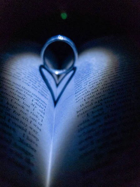 Μια Κάθετη Λήψη Ενός Δαχτυλιδιού Ένα Βιβλίο Σκιά Σχήμα Καρδιάς — Φωτογραφία Αρχείου