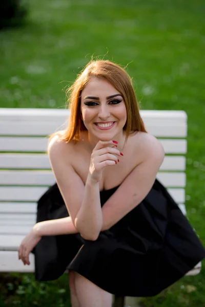 Vertical Shot Smiling Caucasian Female Black Strapless Dress Sitting Bench — 스톡 사진