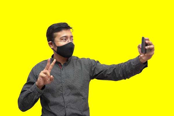 Ung Man Från Indien Svart Facemask Tar Selfie Klargul Bakgrund — Stockfoto