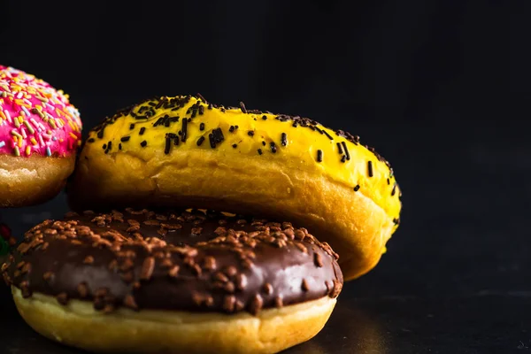 Eine Nahaufnahme Von Glasierten Donuts Mit Streusel Isoliert Auf Schwarzem — Stockfoto