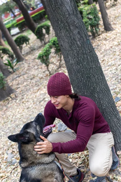 Young Hispanic Man Wearing Beanie Petting His Dog Park — Stock Photo, Image