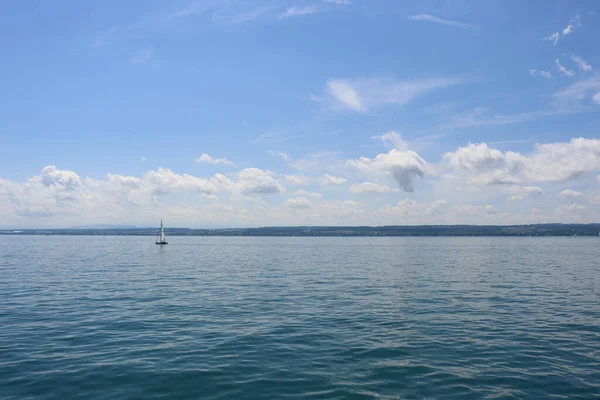 在蓝云的天空下 一艘在宁静的康斯坦茨湖中独自航行的船 — 图库照片