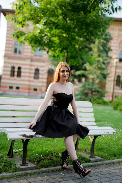 Вертикальный Снимок Белой Женщины Черном Платье Сидящей Скамейке Парке — стоковое фото