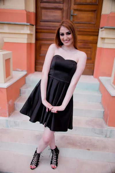 Młoda Atrakcyjna Kobieta Czarnej Sukience Szpilkach Pozująca Schodach Przy Drzwiach — Zdjęcie stockowe