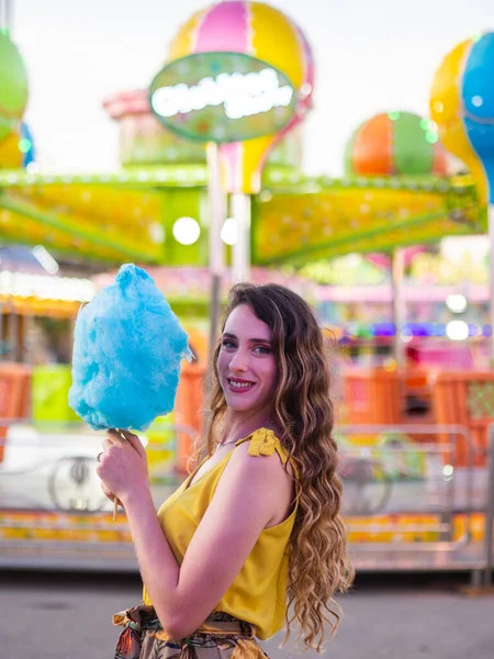 在狂欢节上 一个白种人美女拿着蓝色棉花糖摆姿势的垂直镜头 — 图库照片