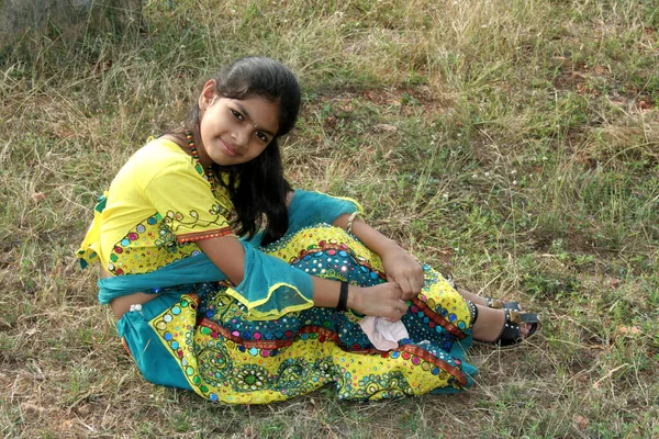 Hampi インド 2010年1月13日 フィールドに草の上に座ってカラフルなドレスで笑顔インドの女の子 — ストック写真