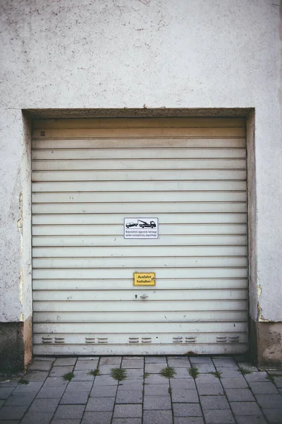 標識付きの白いガレージのドアの垂直ショット 背景のために — ストック写真