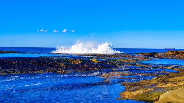 蓝天下岩石海岸的广角镜头 — 图库照片