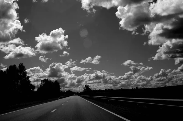 Grayscale Shot Asphalt Road Fields Trees Sides Cloudy Sky — Stock Photo, Image