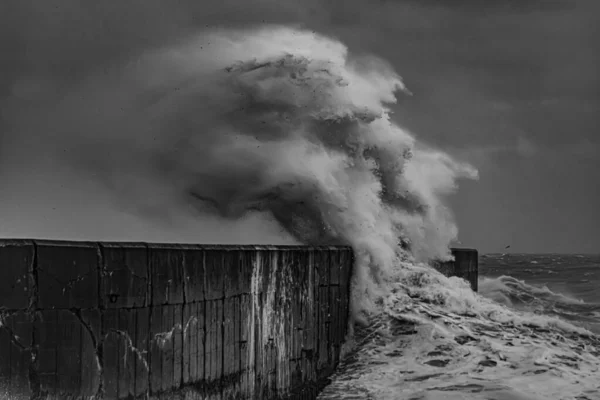 在狂风暴雨的天空下 一道波涛汹涌的大海映衬着墙壁的灰白色镜头 — 图库照片