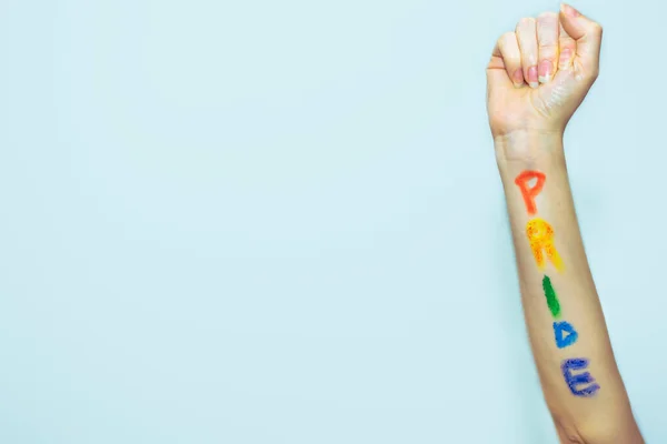 ゲイのプライドの旗の色で彼女の腕に書かれた Pride と女性の上昇拳 — ストック写真