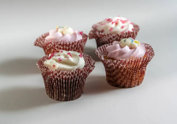 Tiro Close Quatro Pequenos Cupcakes Com Creme Polvilhas Fundo Branco — Fotografia de Stock