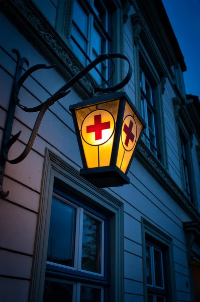 Tiro Vertical Uma Lâmpada Rua Iluminada Com Uma Cruz Vermelha — Fotografia de Stock