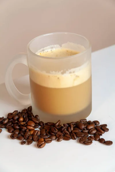 一杯卡布奇诺咖啡和咖啡豆的特写镜头 — 图库照片