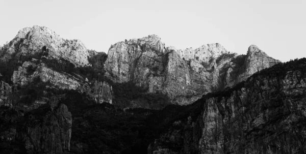 Eine Graustufenaufnahme Felsiger Berge Mit Gipfeln Unter Grellem Sonnenlicht — Stockfoto