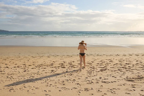 Bikini Hasır Şapkalı Bir Kız Sahilde Yürüyor — Stok fotoğraf