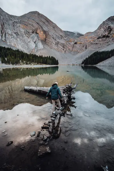 Vertical Shot Mountainous Lake Male Walking Rocks Water — Foto de Stock