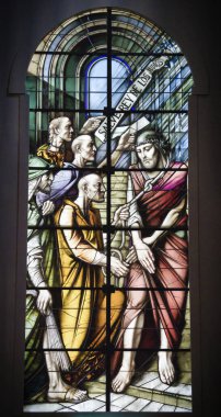 A vertical shot of colorful stained glass window with biblical scene in the cathedral of Segovia clipart