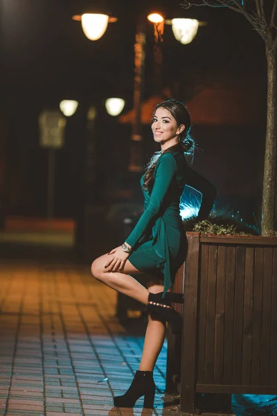 夜の街のエレガントな緑のドレスを着た若い白人女性の垂直ショット — ストック写真