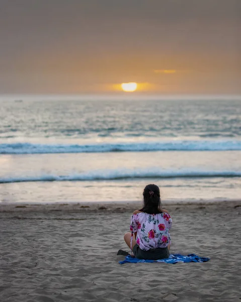 Vertical Shot Young Female Sitting Ocean Beach Sunset — Fotografia de Stock