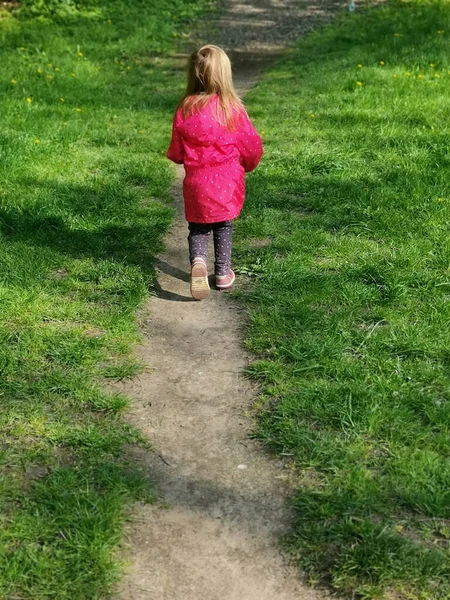 Uma Visão Traseira Vertical Uma Menina Loira Casaco Rosa Andando — Fotografia de Stock