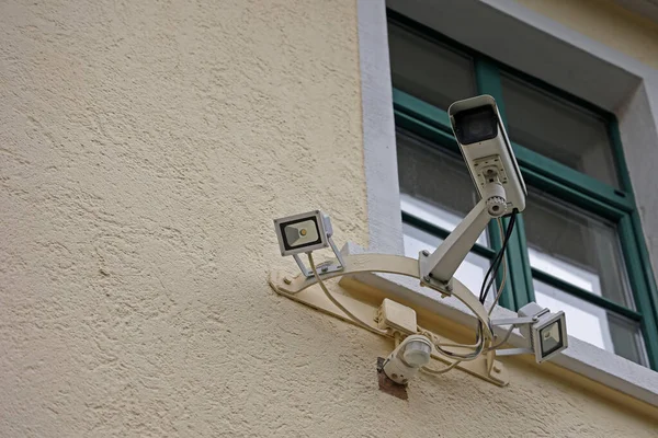 A video camera system below a window on the wall of a building