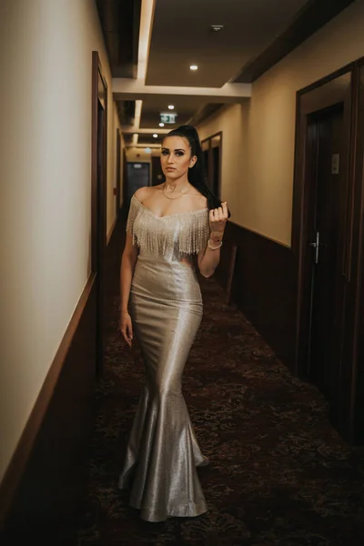 一个年轻性感的女人穿着奢华的晚礼服 在走廊里摆姿势 — 图库照片