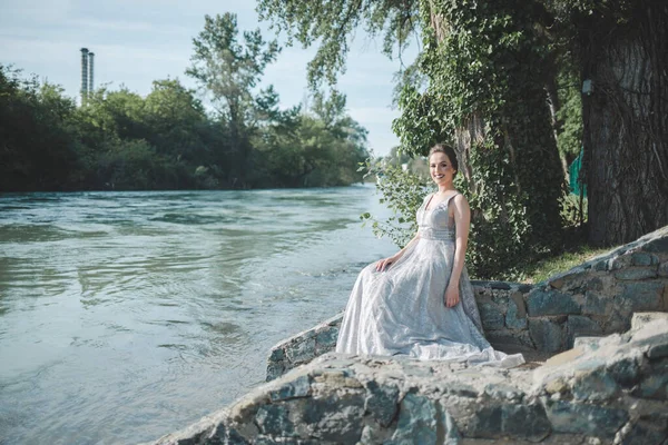 一位年轻迷人的白种人女子 化着妆 身穿漂亮的晚礼服 在湖边摆姿势 — 图库照片