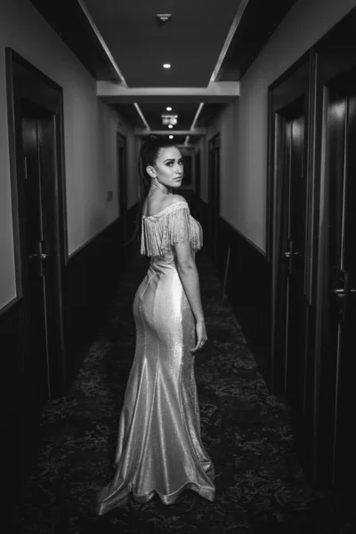 在走廊里穿着雅致衣服的美丽的高加索女人的一个垂直灰度的照片 — 图库照片