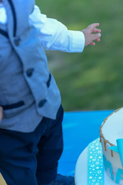 小さな男の子が誕生日ケーキの周りで遊んでいる — ストック写真