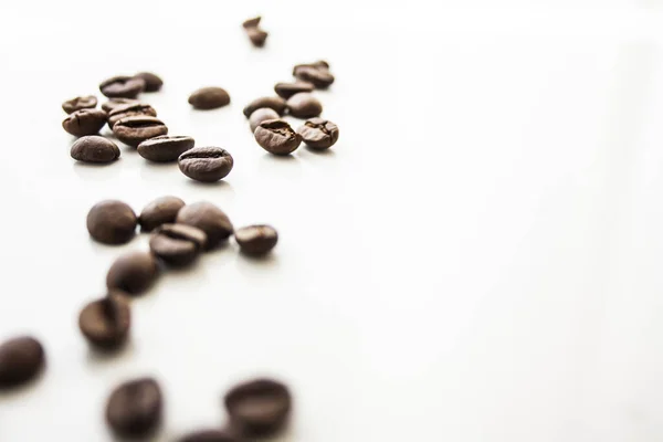 Closeup Roasted Coffee Beans Scattered White Surface Space Text — Stock Fotó