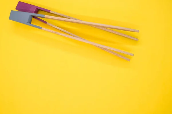 Closeup Two Wooden Cooking Chopsticks Yellow Surface — Φωτογραφία Αρχείου
