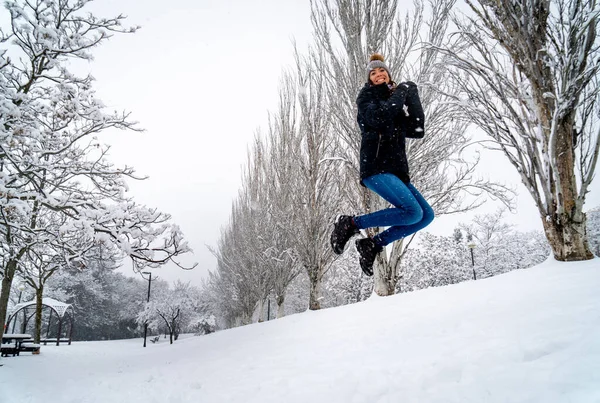 Young Caucasian Female Posing While Jumping Snowy Winter Park — 스톡 사진