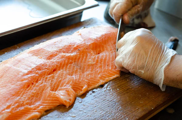 Uno Chef Che Taglia Salmone Con Coltello Una Tavola Legno — Foto Stock