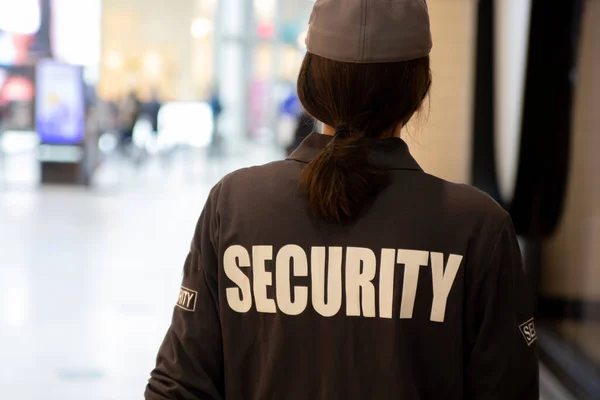 A closeup shot of a female security guard in uniform patrolling a residential area