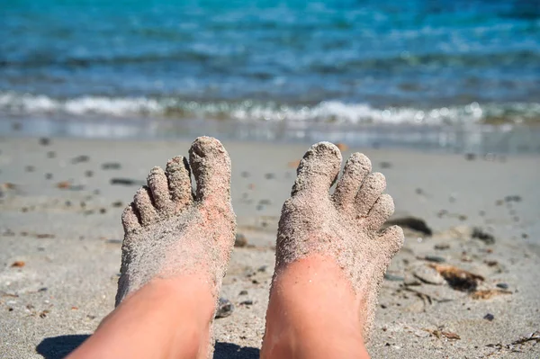 海のビーチで砂の中に裸の足のクローズアップショット — ストック写真