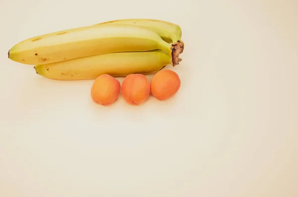 Tiro Ângulo Alto Bananas Maduras Damascos Isolados Fundo Marrom Claro — Fotografia de Stock