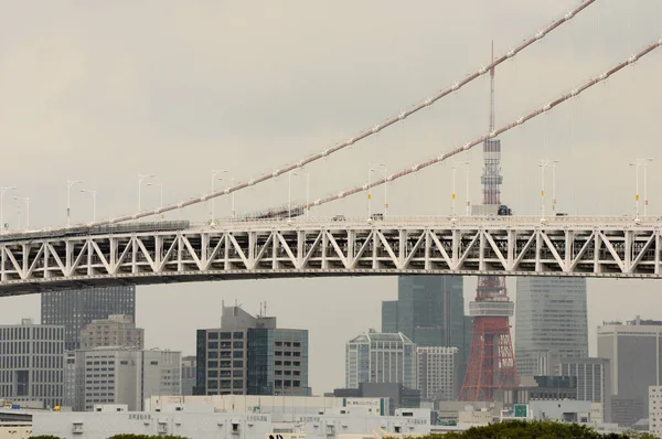 虹の橋の一部が見え そこを横断する交通量と東京タワーを背景にしています — ストック写真