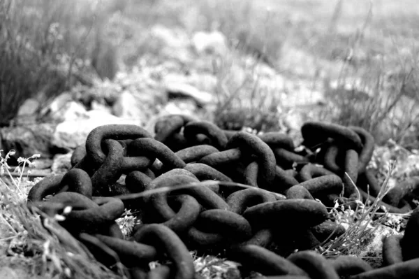 淡淡的锈迹斑斑的铁链 铺在灰蒙蒙的草地上 — 图库照片