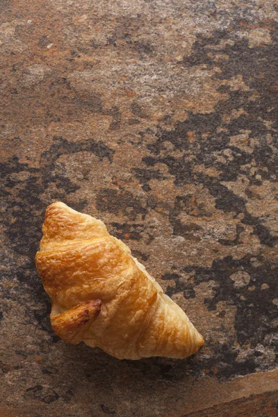 Uma Vista Superior Croissant Fresco Uma Superfície Enferrujada — Fotografia de Stock