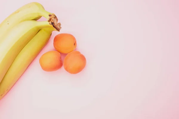 Tiro Ângulo Alto Bananas Maduras Apricotsisolado Fundo Rosa — Fotografia de Stock