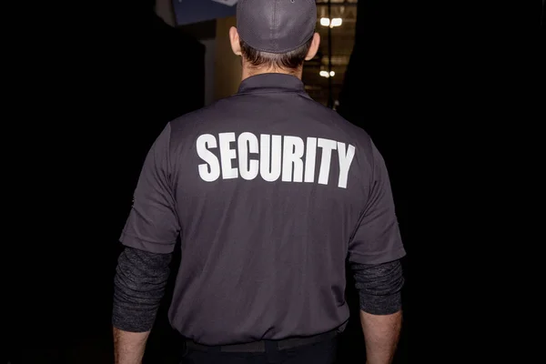 A closeup shot of a security guard in uniform patrolling in a commercial mall
