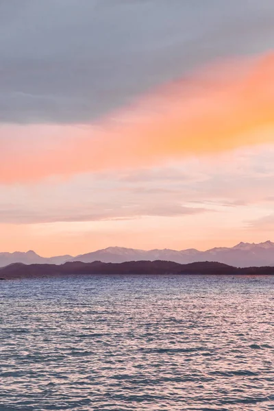 山と海の上にピンクのオレンジの夕日の空の魅惑的なショット — ストック写真