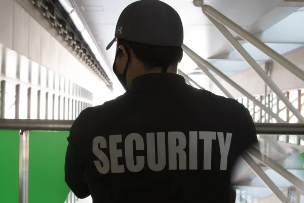 A closeup shot of a security guard in uniform patrolling in a commercial mall